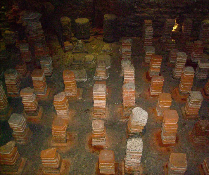The remains of a Roman hypocaust system, with stacks of brick columns that once supported a raised floor.