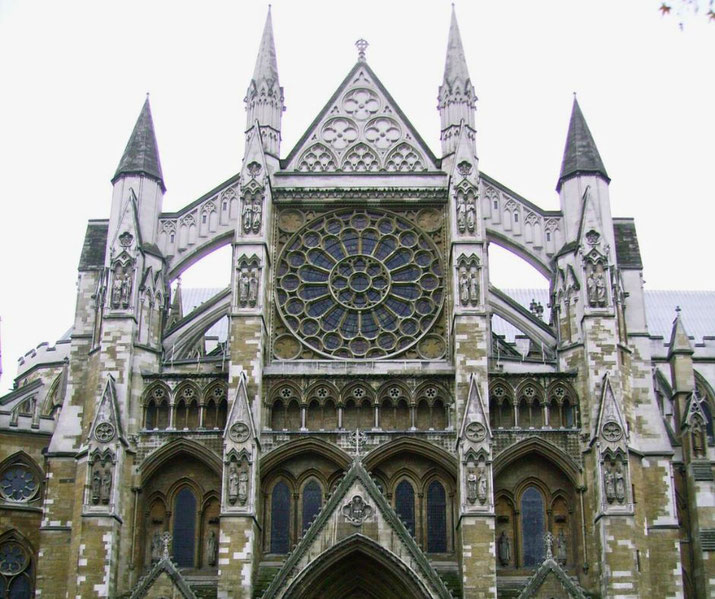 Gothic cathedral facade featuring pointed arches, tall spires, and a large circular stained glass rose window.