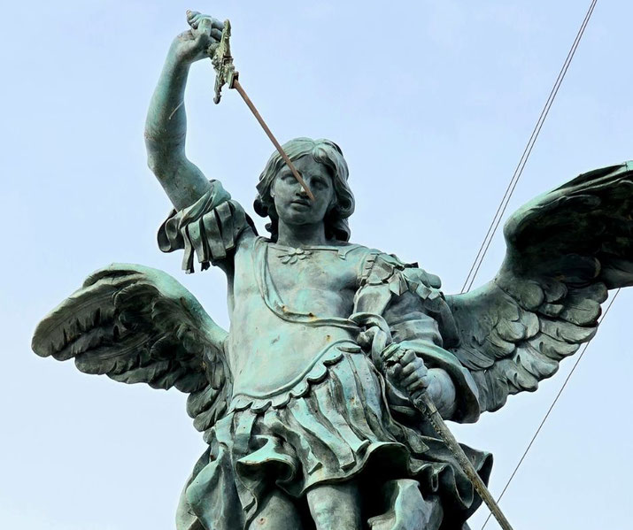 Bronze statue of a winged angel with a sword raised high, dressed in armor, symbolizing strength and divine protection.