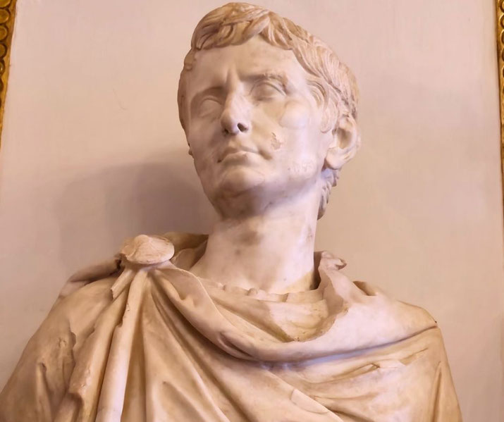 Marble bust of a youthful man with short hair and a calm, stern expression, dressed in a Roman toga with a fibula clasp.