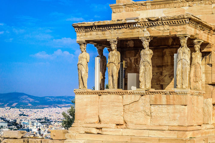 The Erechtheion’s Porch of the Caryatids features six sculpted female figures supporting the entablature, overlooking Athens.