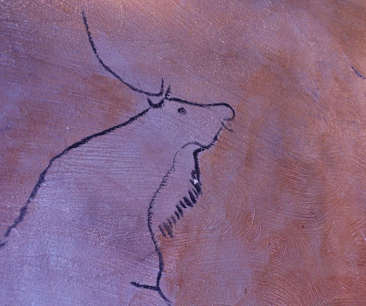 An ancient-style cave painting of a bison or deer, drawn with black lines on a textured, earthy surface. The artwork resembles prehistoric depictions found in early human settlements.
