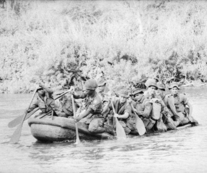 American soldiers ferry 1RAR troops across Song Be River in rubber boat during Operation Silver City, 1966.