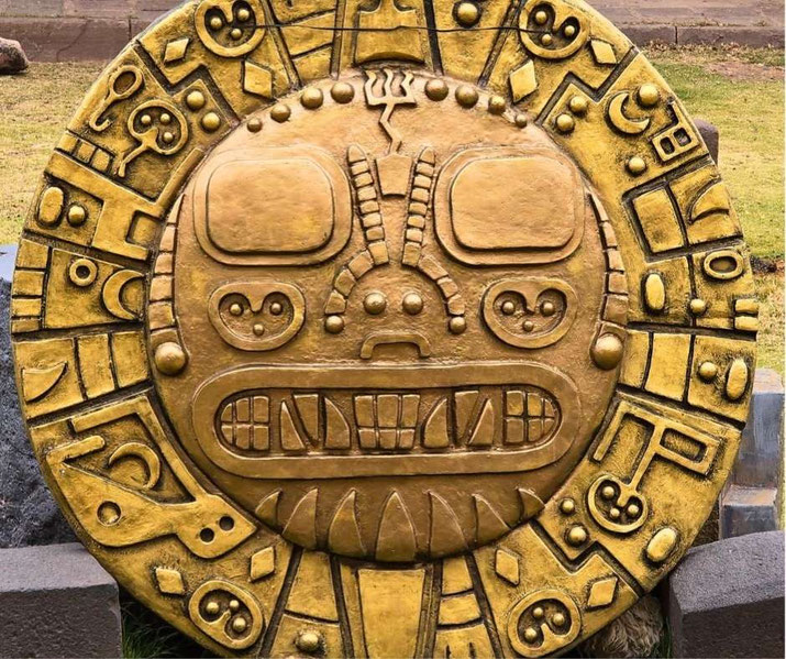 A large golden circular artifact with intricate carvings, possibly inspired by Incan or Mesoamerican motifs.