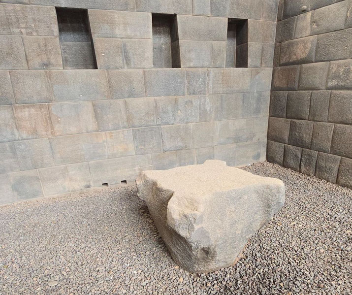 An ancient Incan stone structure with precisely cut walls and trapezoidal niches.