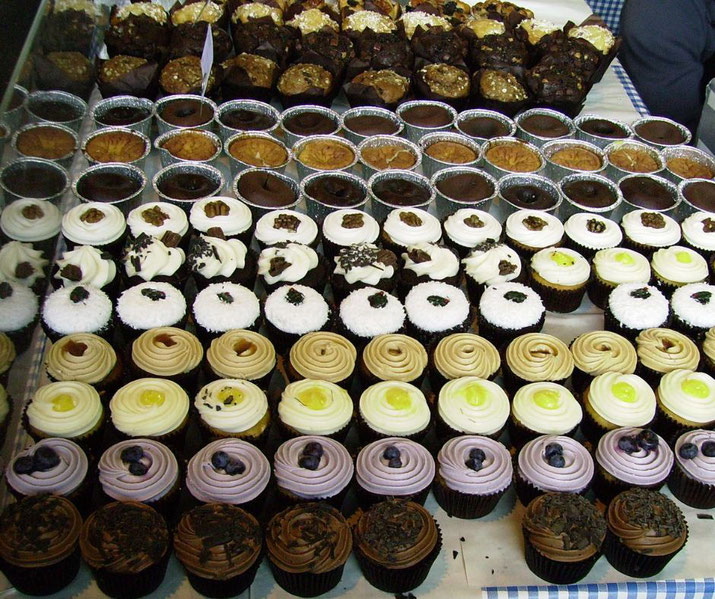 A delicious display of assorted cupcakes and pastries arranged in neat rows.