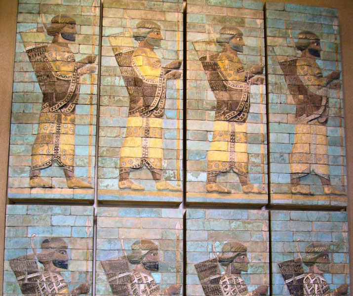 Ancient glazed brick relief showing rows of Persian archers in ornate dress, holding spears and quivers, set against a turquoise background.