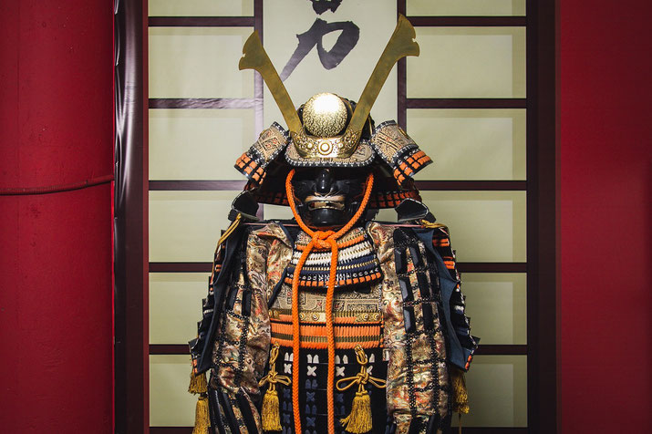 A traditional Japanese samurai armor set with an ornate helmet featuring large golden horns. 