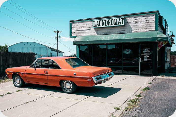 Zeitlos wirkende Reisefotografie eines amerikanischen Oldtimers vor einem Laundromat im Mittleren Westen der USA