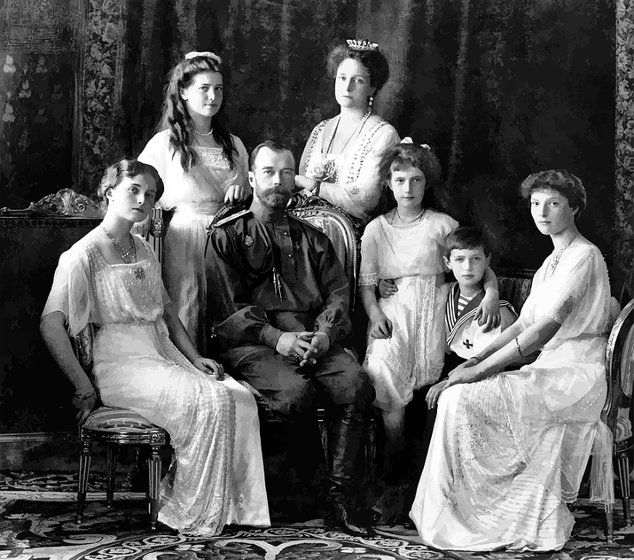 A black-and-white portrait of a royal family, with the father in military uniform, surrounded by his wife and five children in formal attire.
