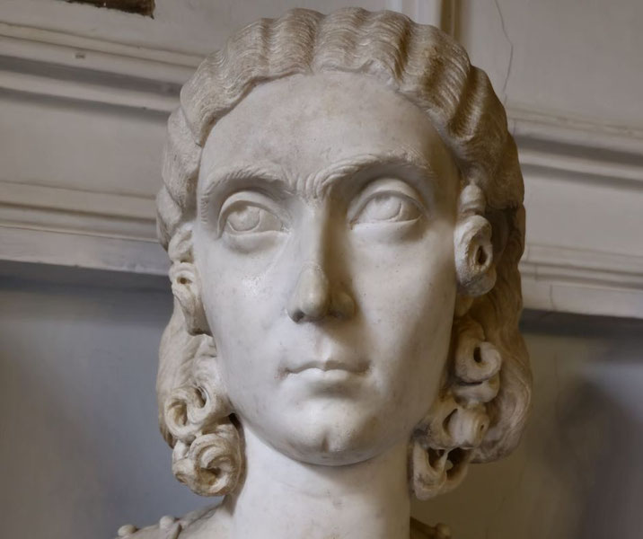 Marble bust of a woman with deeply carved eyes, wavy hair styled in ringlets, and a composed expression.