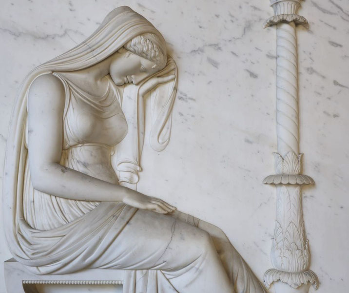 Elegant marble relief of a seated woman in flowing robes, head bowed and hand to her temple, beside a carved decorative column.
