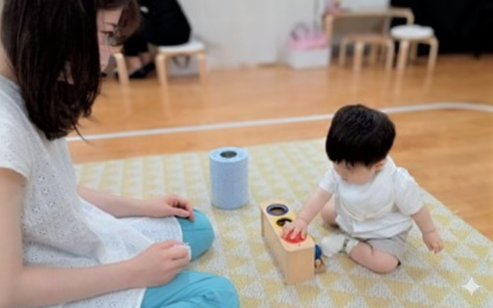 0・1歳児親子クラスのモンテッソーリの活動で、0歳児の活動を見守るお母さま