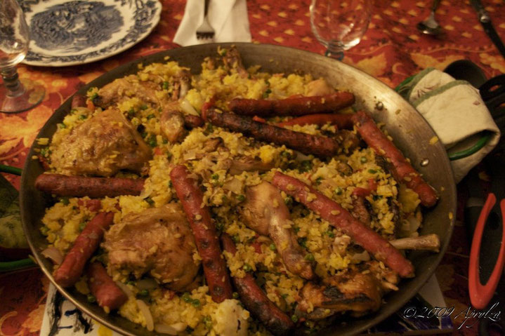 Paella with merguez chorizo grilled chicken mussels shrimp scallops onions peas garlic curcuma