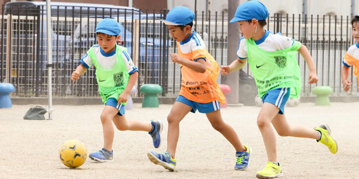 園庭でサッカーをしている子どもたち