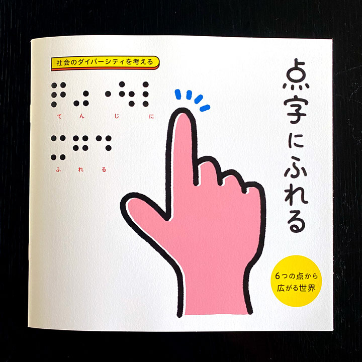 凹凸はなく印字された点字で「てんじにふれる」と書かれているパンフレット。正面入り口の看板とほぼ同じデザイン。パンフレットに音声コードはない。