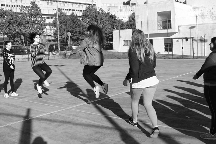 Juego de la comba. Dos alumnas mueven la comba mientras las demás se van incorporando para dar un par de saltos y salir nuevamente.
