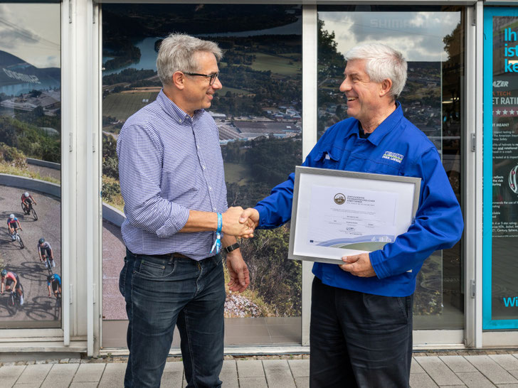 Matthias Zimmermann überreicht Bernhard Lange das Zertifikat „Fahrradfreundlichen Betrieb“ in Gold