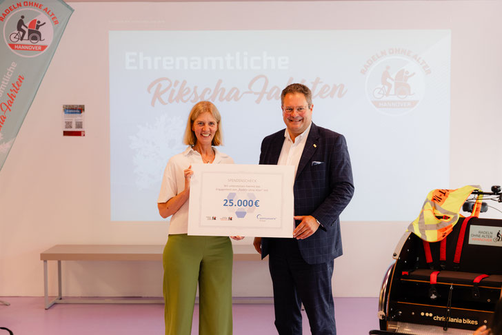 Die Wertgarantie Group hat 25.000 Euro für „Radeln ohne Alter" gespendet. Patrick Döring, Vorstandsvorsitzender, übergibt Stefanie Eichel den symbolischen Scheck. Foto: Wertgarantie 