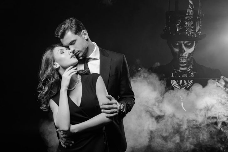 elegantes paar in weissem nebel mit baron samedi in hintergrund