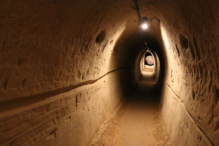 Retzer Erlebniskeller, schwach beleuchteter Tunnel mit Sandwänden und -böden