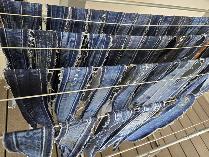 Abgetrennte Jeanshosen-Bünde werden gewaschen und zu neuen, handgefertigten Unikaten vernäht.