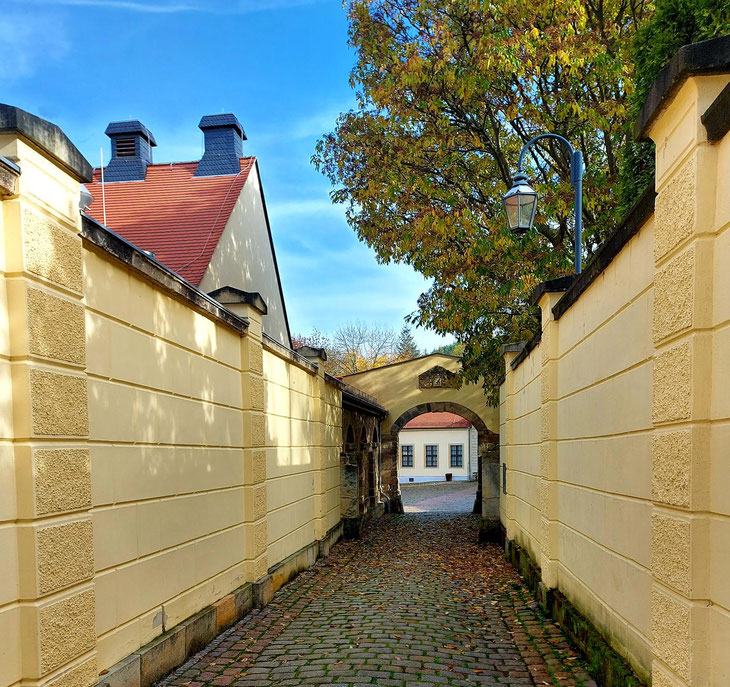 Durch den Torbogen sieht man das Ausstellungsgebäude, ehemalige Wirtschaftsräume von Schloss Burgk.