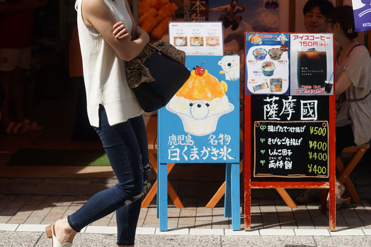 店先の路上に置かれた「鹿児島名物 白くまかき氷」の青い看板。白くまの絵と白くまの顔をしたかき氷が描かれている