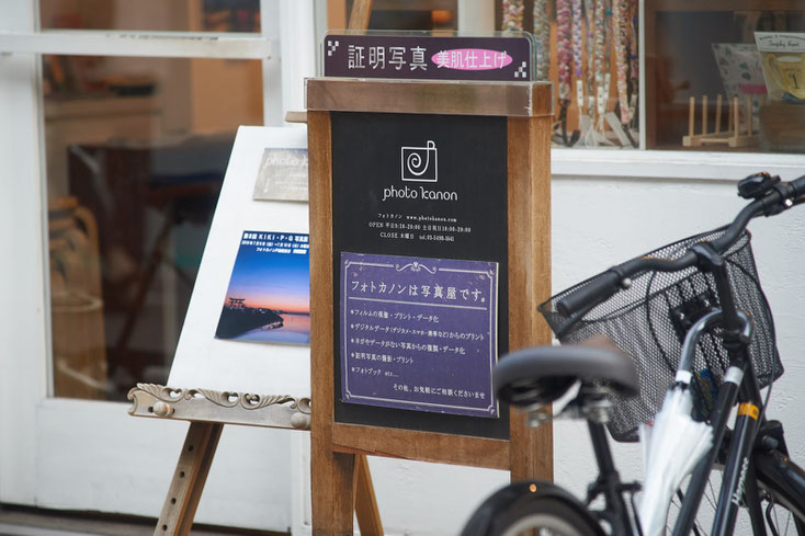 フォトカノンの置き看板には「フォトカノンは写真屋です」と書かれている。