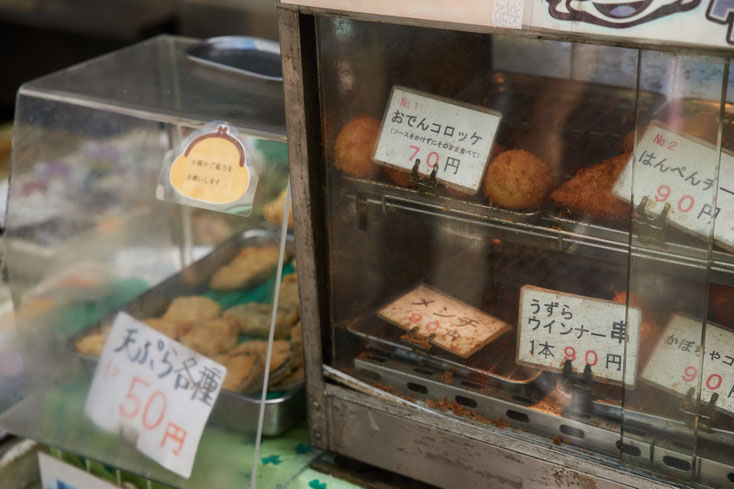 店先に置かれたショーケースに、おでんコロッケ70円、はんぺんチーズ90円、うずらウインナー串90円。天ぷら各種50円。