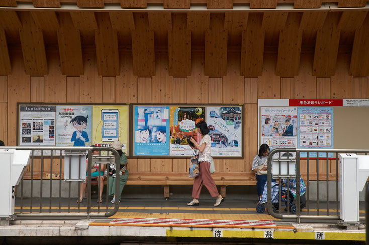 戸越銀座木造駅舎のホームを歩く人、電車を待つ人たち