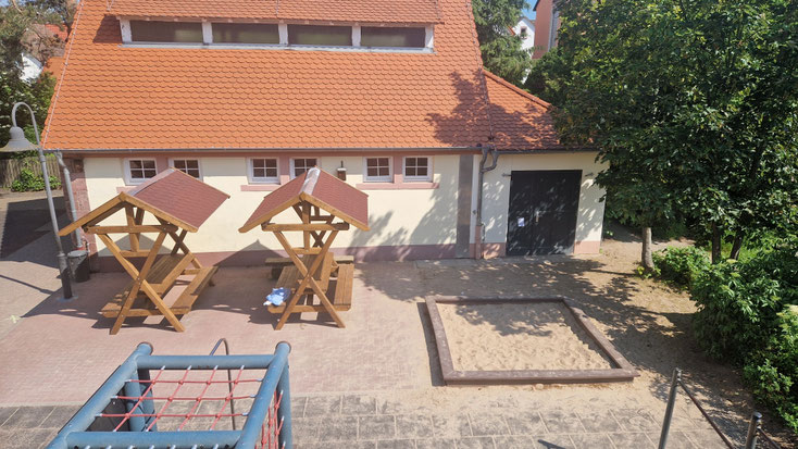 Durch die neuen Sitzbänke ist hier eine schöne Ecke entstanden - Sitzbänke, Spielehäuschen, Schulgarten