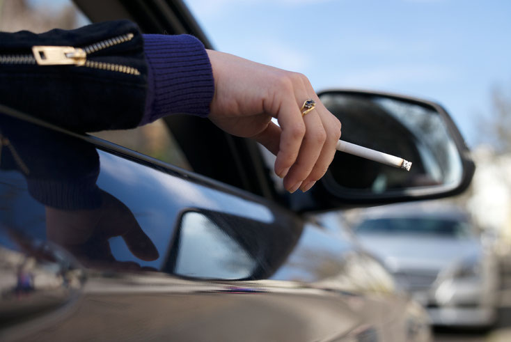 Frau hält Zigarette aus dem Auto; Kurtz Detektei Essen