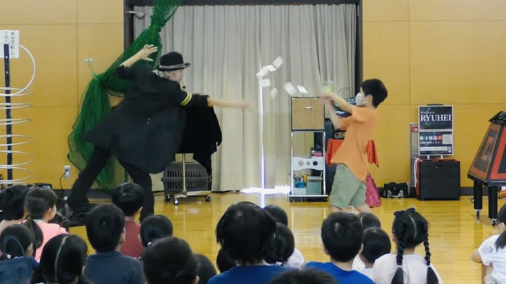 滋賀県の子ども会でマジシャンと子どもがトランプマジックをしている