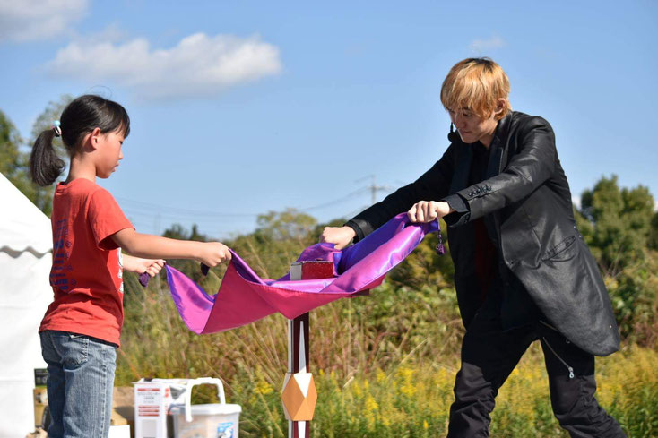 愛知県名古屋市の野外パフォーマンスでテーブルを浮かせる出張マジシャンRYUHEIと子ども