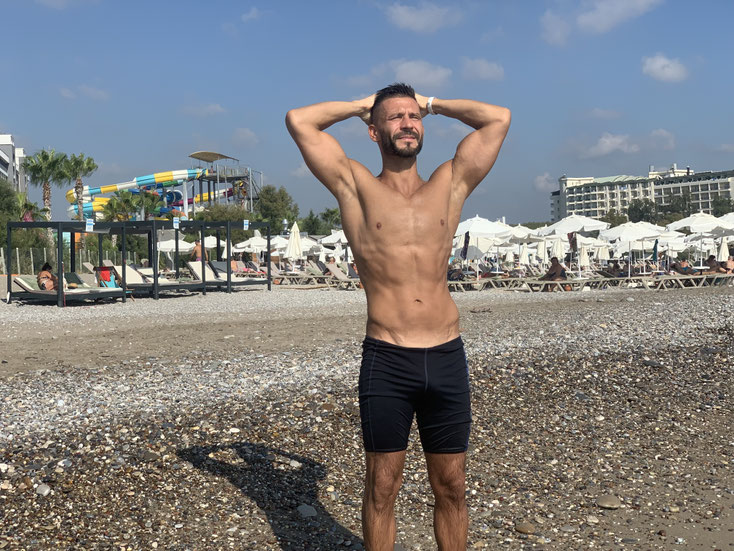 Körper betontes Posen nach einer Bodytransformation mit Fettverlust und Gewichtsreduktion und abnehmen und Muskelaufbau - FitMitSly Healthengineers Salih Sara Personal Training Personal Trainer Köln Online