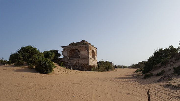 Hier guckt nur noch die Spitze eines Turmes aus dem Sand
