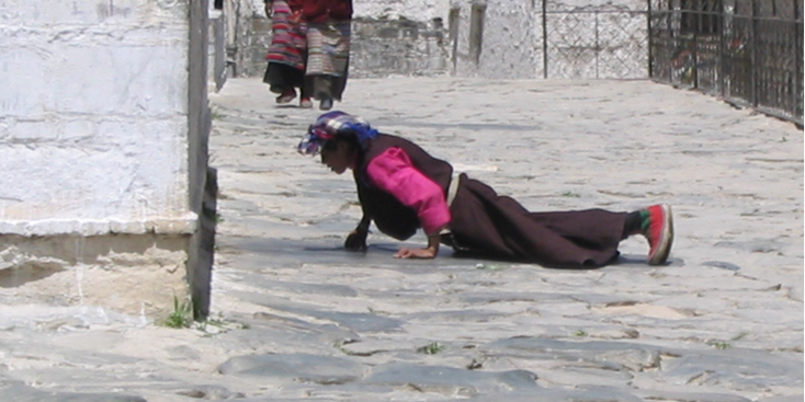 Shigatse-biddende-vrouw-op-grond-Tibet-China