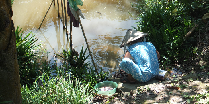 Mekong-delta-huisje-hutje-kanalen-rivieren-Vietnam-vrouw-vis-vangen-waterkant