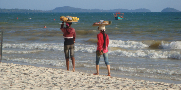 Sihanoukville-Cambodja-strand-zon-zand-zee-verkoopsters-fruit-op-hoofd