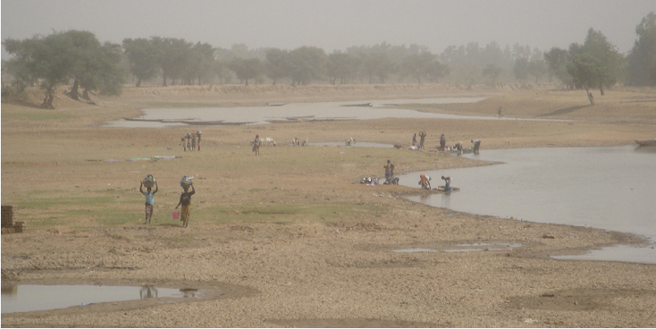 Djenne-rivier-vrouwen-water-halen-ketel-op-hoofd-bedding-Mali