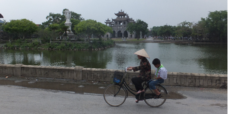 Phat-Diem-kathedraal-meer-eiland-Christus-beeld-Katholiek-Vietnam-fiets