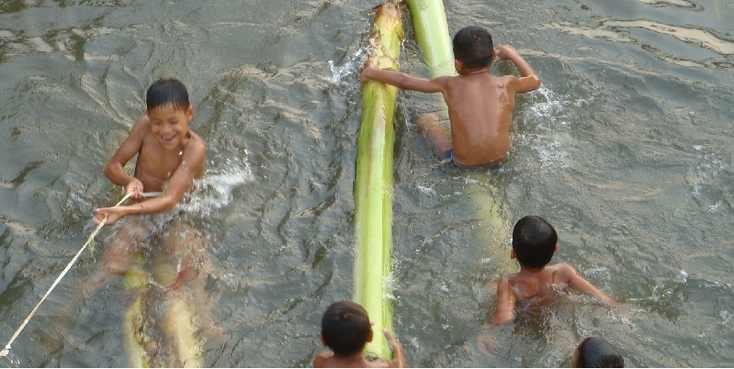 Vang-Vieng-kinderen-spelen-rivier-bamboe-Laos