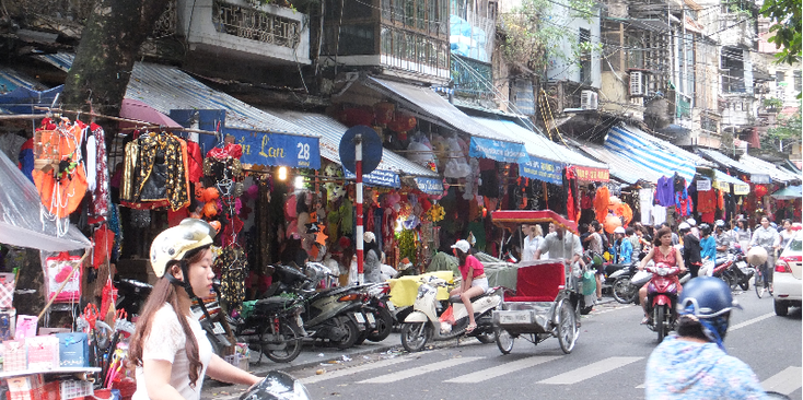 Hanoi-tuk-tuk-cyclo-scooter-winkels-stalletjes-straatleven-druk-Vietnam