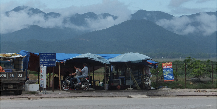 Dien-Bien-Phu-stalletjes-scooter-bergen-mist-Vietnam