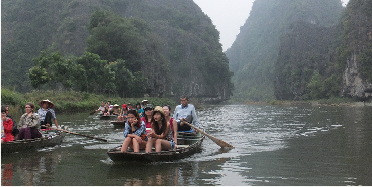 Tam-Coc-rivier-boten-toeristen-Karst-gebergte-bergen-roeien-voeten-Vietnam