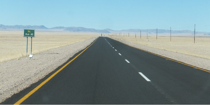 Aus-Namib-woestijn-weg-asfalt-bord-verkeersbord-Namibië