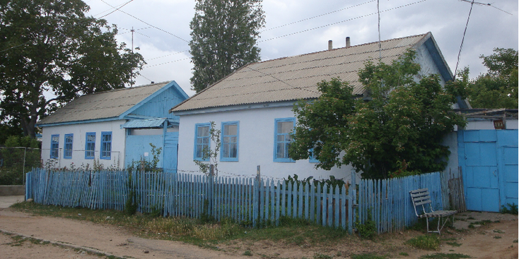 Chaplan-Ata-houten-huis-blauw-wit-hek-Kirgizië