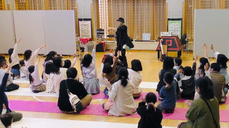 マジシャンRYUHEIと手を上げる愛知県小牧市の子ども達