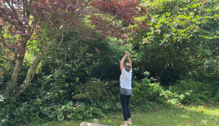 Woman stretching in the garden on a yoga retreat with Julia Poole